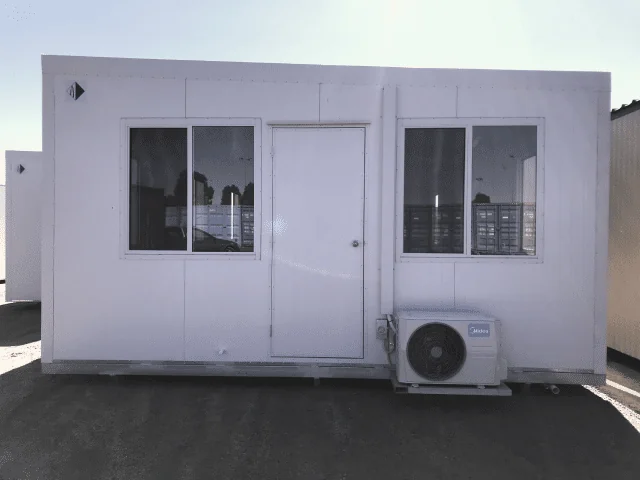 White portable lunchroom with a central sliding glass door between two windows, and a split-system condenser unit at ground level to the right.