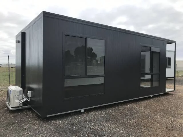 Charcoal sales office with large windows and a sliding glass door, with a condenser unit at the left-hand end.